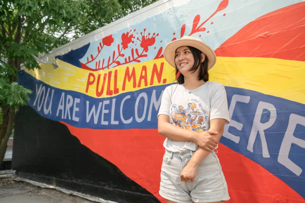 Artist Jiemei Lin in front of her rooftop BLM mural