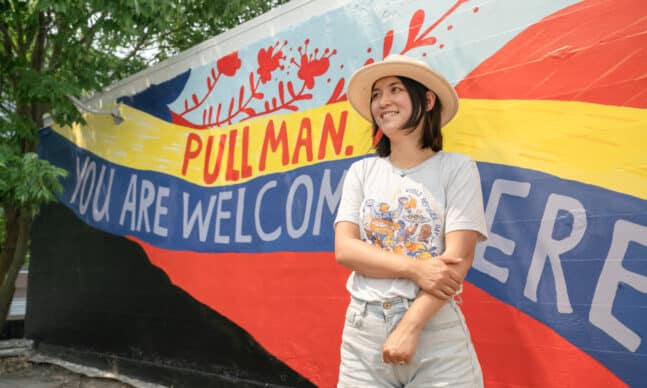 Artist Jiemei Lin in front of her rooftop BLM mural