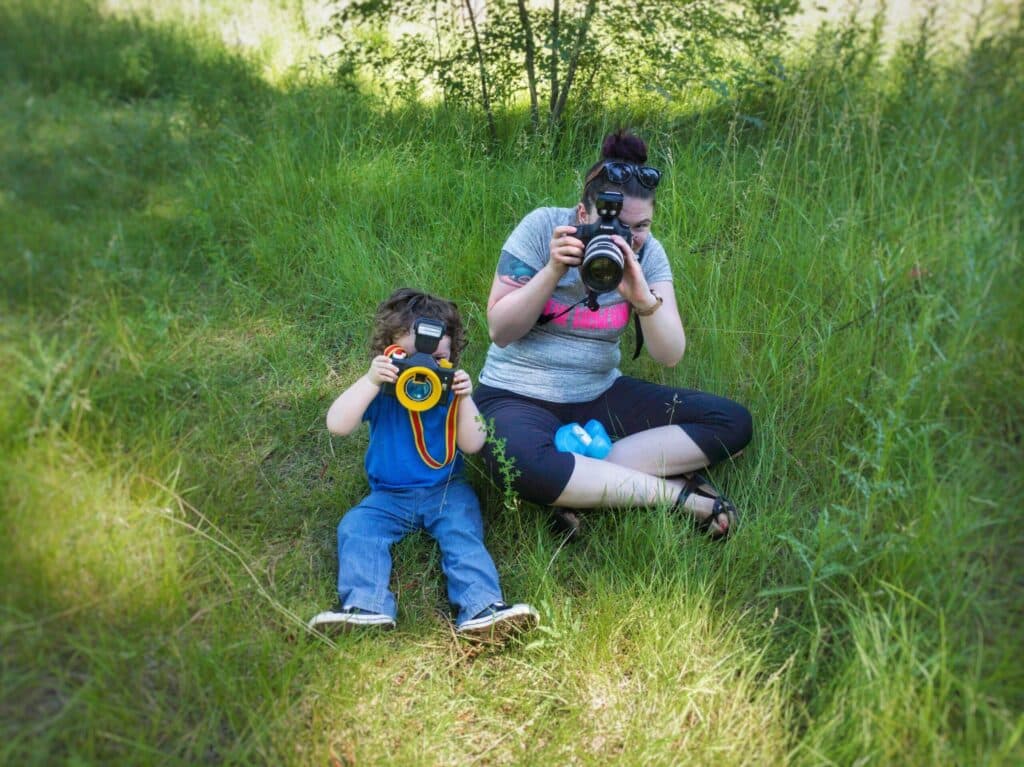 Janessa with her camera, sitting in the grass