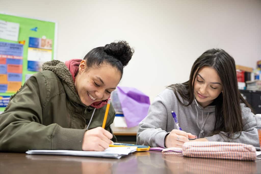 photo of two students writing at a desk at Community College of Spokane